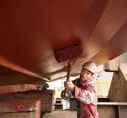 mężczyzna malujący statek